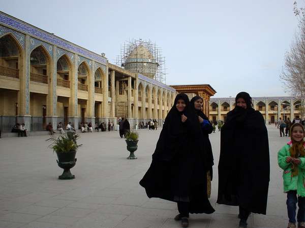 photo of Iran, Esfahan (Isfahan), three Iranian women and a child walking on the Imam square